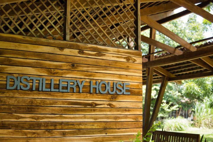 Wooden wall with 'Distillery House' sign, outdoor setting.