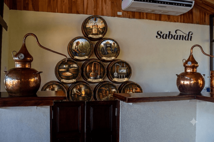 Copper distillery equipment and decorative barrels on a wooden counter.