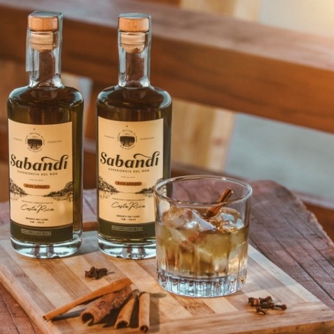 a glass of wine sitting on top of a wooden cutting board