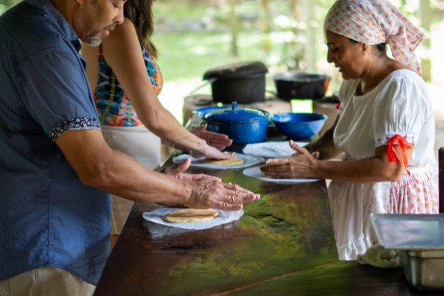 a man cooking food on a picnic table