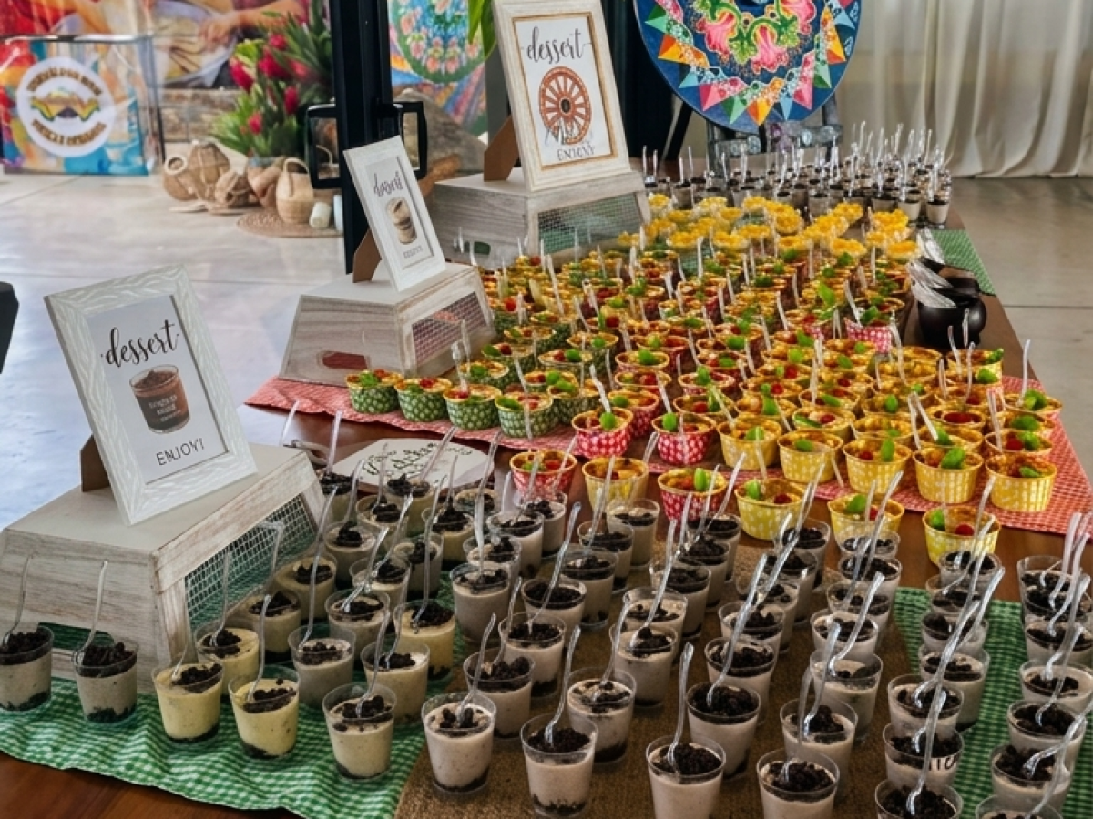 Dessert table with colorful fruit and chocolate cups in a bright room.