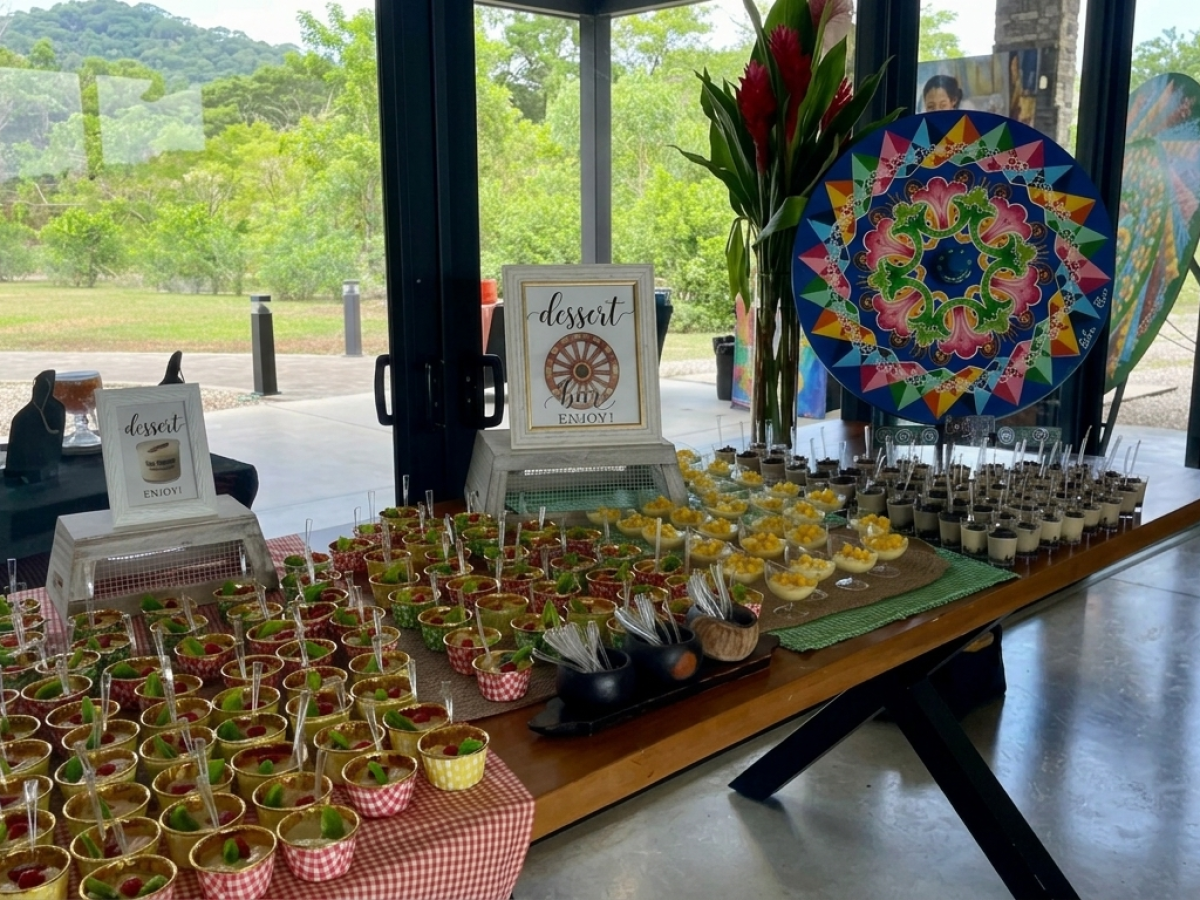 Buffet table with desserts and decorative art by a window.