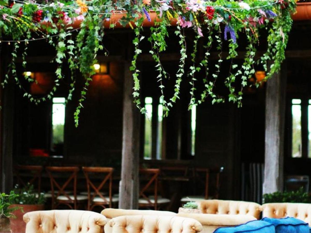 Outdoor seating area with colorful sofas and floral decorations.