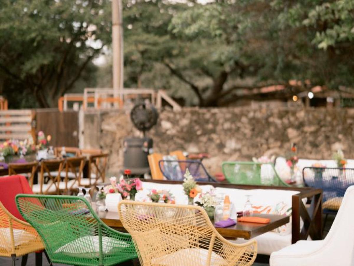 Colorful outdoor seating with wicker chairs and string lights