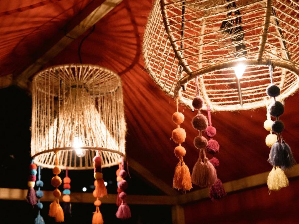 Decorative rope lampshades with colorful tassels hanging from a ceiling.